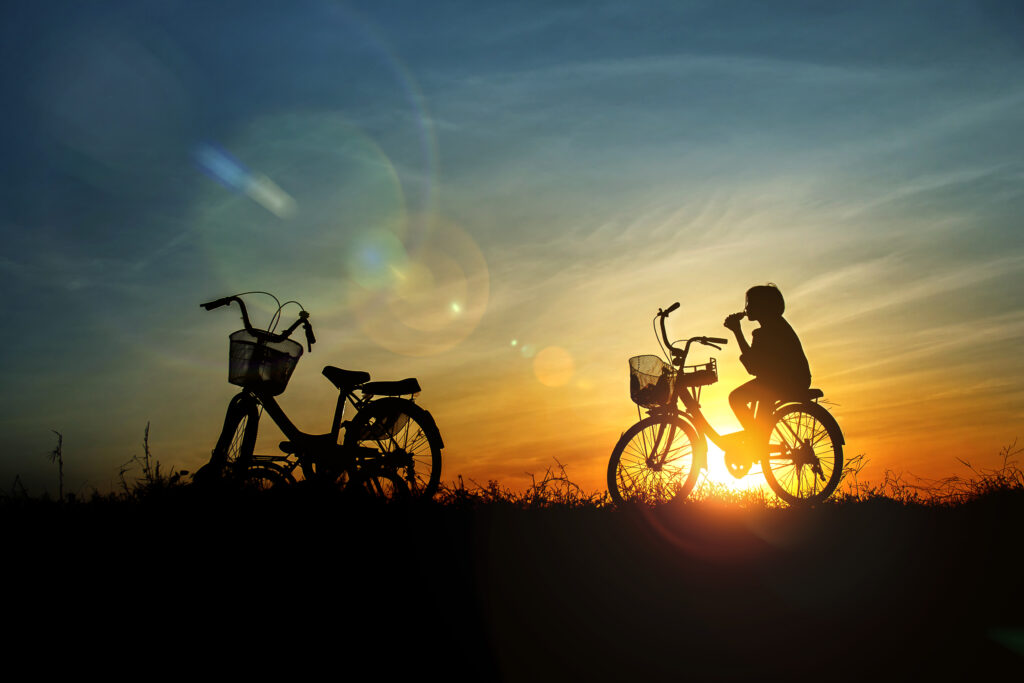 Bambina in bicicletta al tramonto