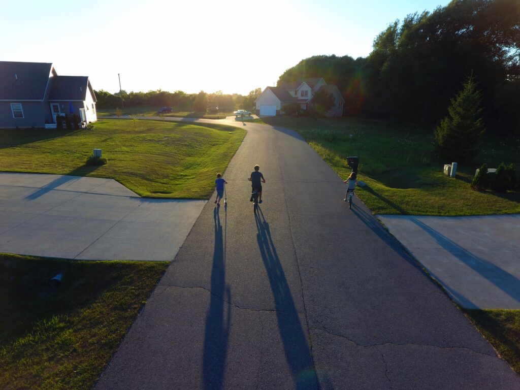 Ragazzi in bicicletta al tramonto lungo una strada di provincia