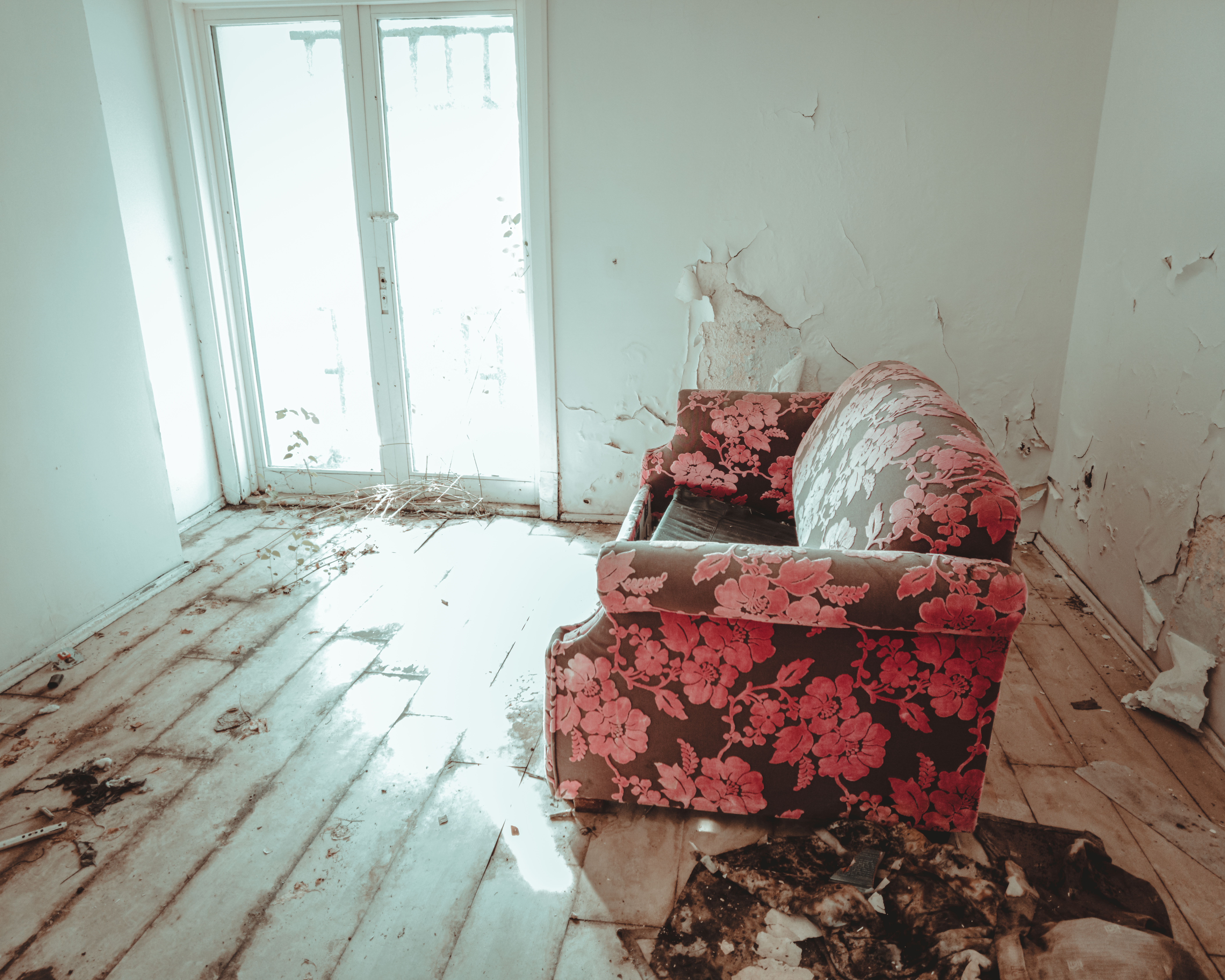 Salotto abbandonato con divano floreale e pareti scrostate, atmosfera Southern Gothic